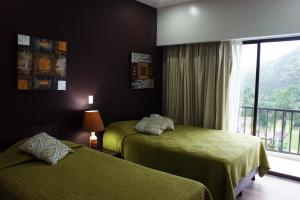 a hotel room with two beds and a window at Luxury Condo Jaco Beach in Jacó