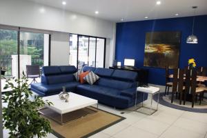 a living room with a blue couch and a table at Luxury Condo Jaco Beach in Jacó