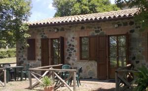 ein Steinhaus mit einem Tisch und Stühlen davor in der Unterkunft Agriturismo Pomonte in Orvieto