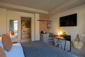 a bedroom with a bed and a desk and a kitchen at Can Aulí Luxury Retreat - Adults Only in Pollença