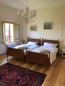two twin beds in a bedroom with a rug at La Torre di Rua in San Pietro di Feletto