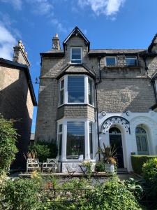 a large stone house with a white front door at Sundial Stays Kendal in Kendal