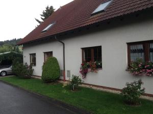 una casa bianca con fiori alle finestre di Ferienhaus Morgensonne a Neustadt in Sachsen