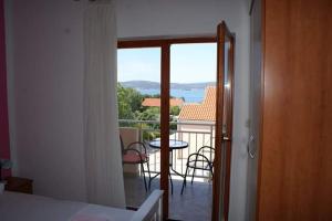 a room with a balcony with a table and chairs at Apartments Vodopija 300m to the beach in Sveti Filip i Jakov