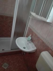 a white sink in a bathroom next to a shower at Apartments Vodopija 300m to the beach in Sveti Filip i Jakov
