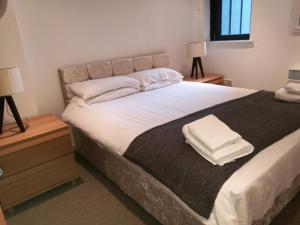 格拉斯哥的住宿－Glasgow Central Riverview Luxury Apartment (Sleeps upto 8)，卧室配有一张带白色床单和枕头的大床。