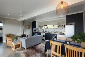 a living room and kitchen with a couch and a table at The Riverstone House in Romansrivier
