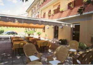 eine Terrasse mit Tischen und Stühlen und ein Gebäude in der Unterkunft Hotel Monna Lisa in Vinci
