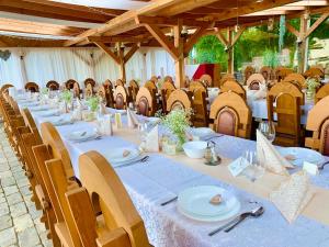 a long table with plates and napkins on it at Strázsa Vendégház in Szekszárd