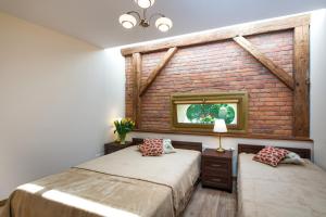 a bedroom with two beds and a brick wall at Vanilla 7 Apartment in Kraków