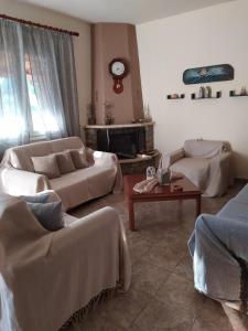 ein Wohnzimmer mit 2 Sofas und einem Tisch in der Unterkunft Garden's Villa in Leptokaryá