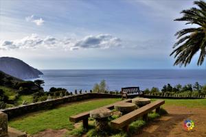 a park bench with a view of the ocean at Casa Rural O Rabadan in Cedeira +4 photos