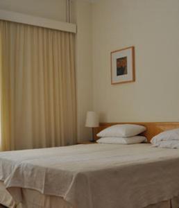 a bedroom with a large bed with white sheets at Miami Hotel in Mati