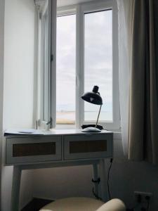 een lamp op een bureau voor een raam bij Sea View in Saint-Gilles-Croix-de-Vie