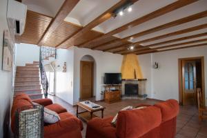 ein Wohnzimmer mit orangefarbenen Sofas und einem Kamin in der Unterkunft Villa Javi in Riumar