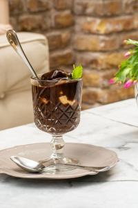 a dessert in a glass on a table with a plate at Marpessa Hotel & Spa in Agrinion