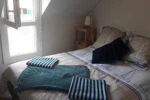 ein Schlafzimmer mit einem Bett mit zwei Handtüchern darauf in der Unterkunft Le cottage de Guidel in Guidel