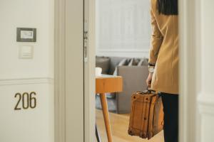 a woman standing with a suitcase in a room at Marpessa Hotel & Spa in Agrinion