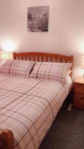 a bedroom with a bed with a plaid blanket at Comfy Home in Aberdeen