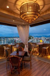 a balcony with tables and chairs and a large chandelier at Marpessa Hotel & Spa in Agrinion