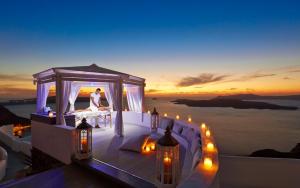 a bride and groom in a gazebo with lights at Volcano View by Caldera Collection in Fira