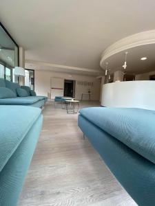 um quarto com sofás azuis e uma mesa em Le Grazie Hotel em Assis