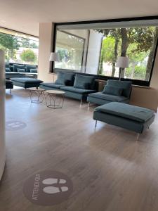 ein Wohnzimmer mit Sofas und Tischen in einem Gebäude in der Unterkunft Le Grazie Hotel in Assisi