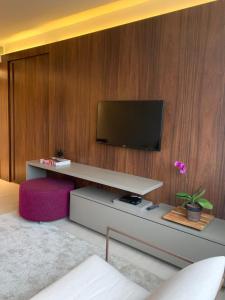 a living room with a couch and a television at Bugan Recife Hotel by Atlantica in Recife