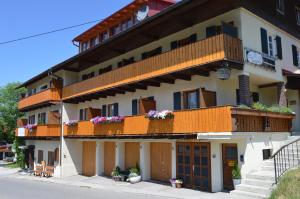 un gran edificio con balcones y flores. en Bed & Breakfast Jungholz - Pension Katharina, en Jungholz