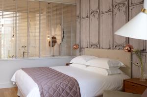 a bedroom with a bed with white pillows and a window at Marpessa Hotel & Spa in Agrinion