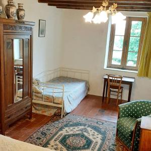 een slaapkamer met een bed, een tafel en een stoel bij Gîte de Rangère in Villapourçon