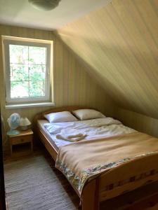 Un pat sau paturi într-o cameră la Żółty Domek nad Jeziorem Lubniewice