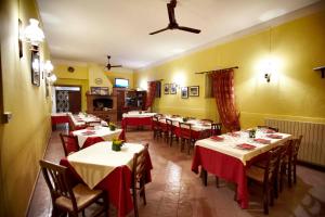 オルヴィエートにあるAgriturismo Pomonteの赤いテーブルクロスのテーブルと椅子が備わるレストラン