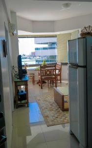 uma cozinha com um frigorífico de aço inoxidável e uma sala de jantar em Flat Beira Mar Golden Fortaleza em Fortaleza