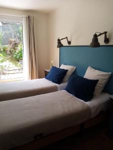 dwa łóżka w pokoju z oknem w obiekcie Dorre Pean w mieście Ciboure