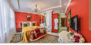 a bedroom with red walls and a bed and a chandelier at Center Residence 3 bedroom 3 bathroom in Budapest