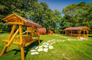 a wooden playground with a gazebo in a field at Casa Nitu in Întorsura Buzăului