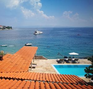 um barco no oceano com um navio de cruzeiro na água em Bella Vista apartments with hot pool and jacuzzi em Trogir