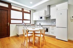 een keuken met witte kasten en een tafel en stoelen bij VUT San Cristóbal LARANITASALAMANTINA in Salamanca +12 foto's