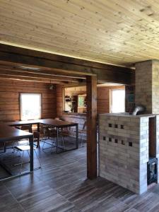 ein Zimmer mit Tischen und Stühlen in einer Hütte in der Unterkunft Pas Garfildą in Vatušiai
