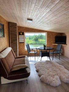 a living room with a couch and a table and chairs at Pas Garfildą in Vatušiai