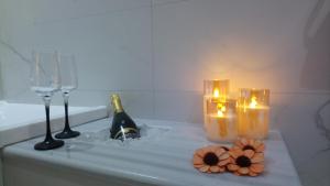 Rhodes Demetrius Luxury Private Villa في كالاثوس: حوض استحمام مع الشموع وكؤوس النبيذ والزهور