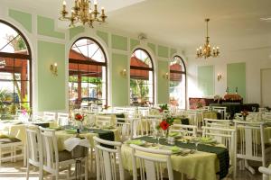 a dining room with white tables and chairs at Axos in Platanes