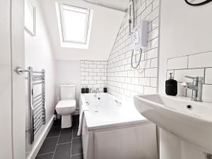 een witte badkamer met een wastafel en een toilet bij Richmond Apartments by Switchback Stays in Cardiff +48 foto's