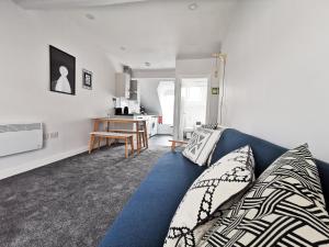 een woonkamer met een blauwe bank en een tafel bij Richmond Apartments by Switchback Stays in Cardiff