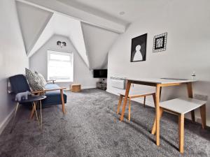 ein Wohnzimmer mit einem Schreibtisch und einem Stuhl in der Unterkunft Richmond Apartments by Switchback Stays in Cardiff