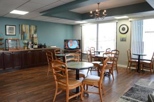 a dining room with tables and chairs and a tv at Clarksville Inn in Clarksville