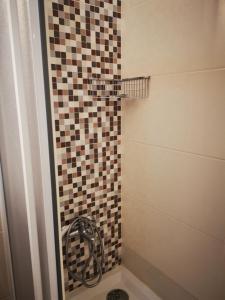 a bathroom with a shower with a tiled wall at Mira Parque in Albufeira