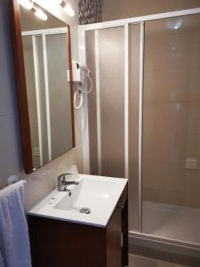 a bathroom with a white sink and a shower at Mira Parque in Albufeira
