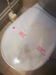 a white toilet with two stickers on the lid at Mira Parque in Albufeira